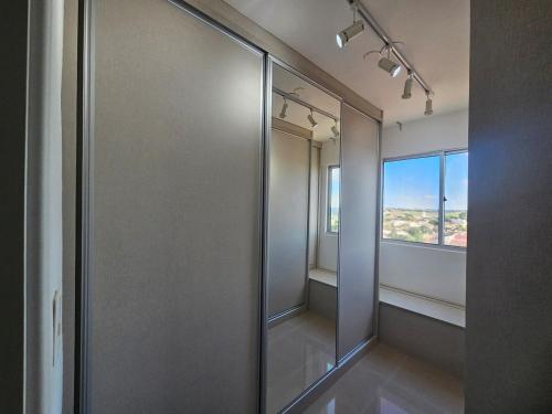a walk in shower in a room with a window at Apartamento Charmoso - Um Espaço de Harrison in Sarandi