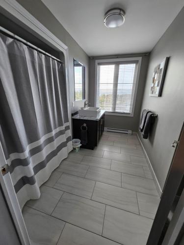 a bathroom with a sink and a shower curtain at Newfound Inn & Suites in Topsail