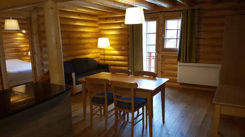 a room with a table and chairs and a bedroom at Hôtel Résidence Le Pin Sylvestre Amnéville in Amnéville