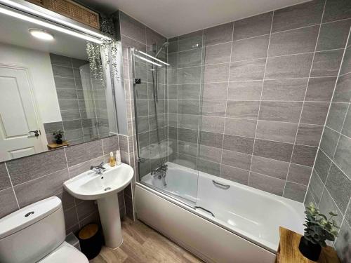 a bathroom with a sink and a tub and a toilet at Lovely 2 bedroom home in Enham-Alamein