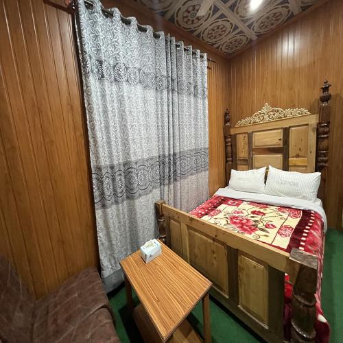 a small bedroom with a bed and a table at Blue Sky Hotel & Restaurant in Skardu