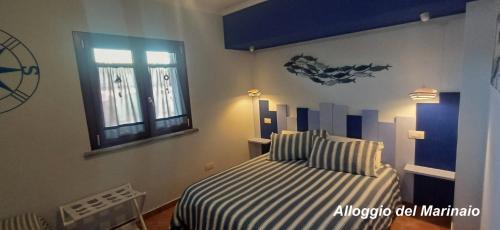 a bedroom with a striped bed and a window at Alloggi Turistici con Piscina Palestra Jacuzzi Sauna - All Inclusive in Anzio