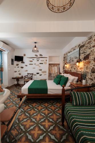 a bedroom with a large bed and a couch at Burgos Barrio Naxos in Naxos Chora