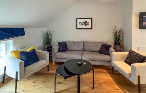 Una sala de estar con un sofá y dos sillas y una mesa. en Lovely Apartment In Søgne With Wifi, en Søgne