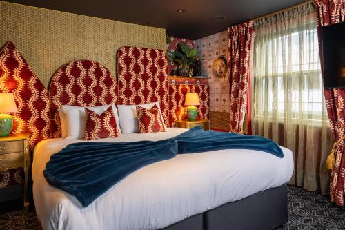 a bedroom with a large bed with red and white pillows at The Kings Arms Pub & Boutique Rooms in London