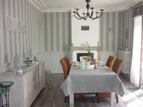 une salle à manger avec une table et une cheminée dans l'établissement Les Champs de Tracy, à La Graverie