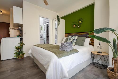 sypialnia z białym łóżkiem i zielonymi ścianami w obiekcie Beach Studio Apartment Playa Malagueta w Maladze
