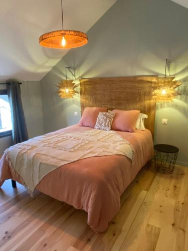 une chambre avec un grand lit avec des oreillers roses dans l'établissement Villa Julorian proche Saint Emilion au cœur des vignobles, à Sainte-Colombe
