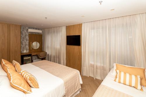 a hotel room with a bed and a television at Mar Ipanema Hotel in Rio de Janeiro