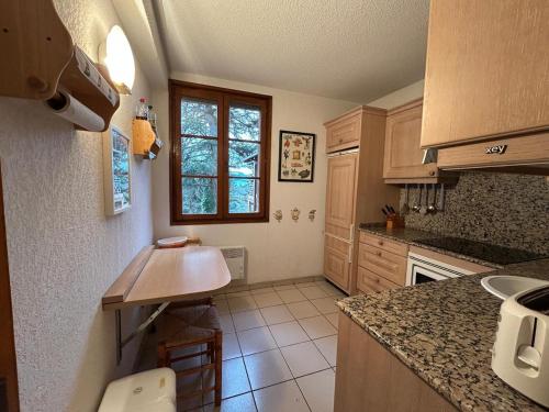 une cuisine avec des armoires en bois et un comptoir dans l'établissement Amplio apartamento con gimnasio y piscina, ideal familias, à Enveitg