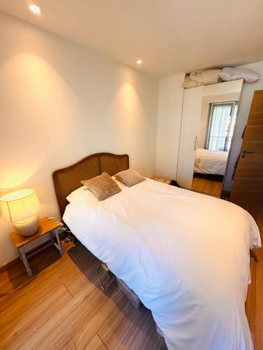 une chambre avec un grand lit blanc et une fenêtre dans l'établissement Les Floralies - Beaulieu-sur-Mer, à Beaulieu-sur-Mer