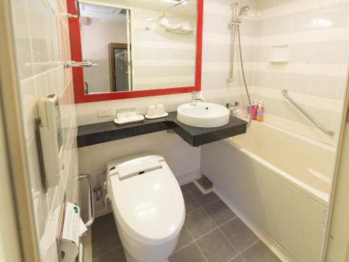 La salle de bains est pourvue de toilettes blanches et d'un lavabo. dans l'établissement Sotetsu Fresa Inn Tokyo-Akasaka, à Tokyo