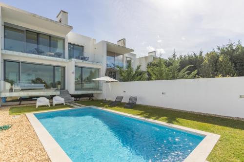 a villa with a swimming pool and a house at Lemon Tree Home in Sesimbra
