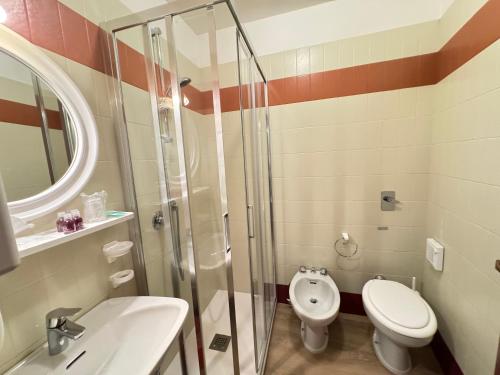 a bathroom with a toilet and a sink and a shower at Hotel Europa in San Martino di Castrozza