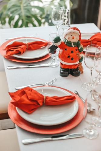 a table with plates and glasses and a santa claus figurine on top at Marambaia Hotel e Convenções in Balneário Camboriú