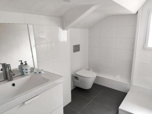 une salle de bain blanche avec des toilettes et un lavabo dans l'établissement Charmante Maison Familiale avec Vue Mer à Port Navalo - 8 personnes - FR-1-639-137, à Arzon