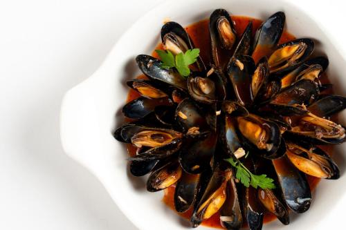 a bowl of mussels in a tomato sauce at Hotel Jaizkibel in Hondarribia