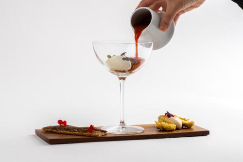 a person pouring chocolate sauce into a wine glass at Hotel Jaizkibel in Hondarribia