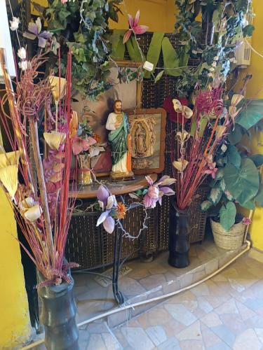 a altar with a statue and flowers in vases at Hospedaje Barato Mi Casita de Colores in Tijuana