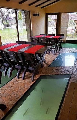 a row of tables in a room with red tables at House Of River in Moieciu de Sus
