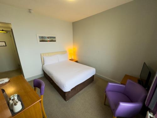 a bedroom with a bed and a desk and a chair at Royal Whitby in Whitby