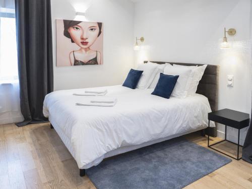 une chambre avec un grand lit blanc avec des oreillers bleus dans l'établissement La Boca Noche Chambres d'Hotes et Gite, à Saint-Antonin