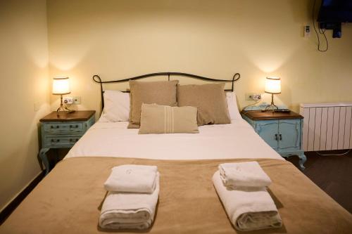 a bedroom with a large bed with towels on it at Loft El Roure, El Vilosell in El Vilosell