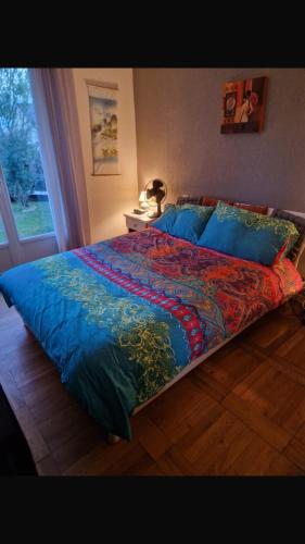 une chambre avec un grand lit avec une couette bleue dans l'établissement Tajitu chambre table d hôte naturiste FKK, à Chartres