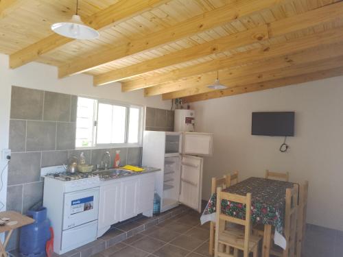 a kitchen with a white refrigerator and a table at CaSa VALENTINA in San Clemente del Tuyú