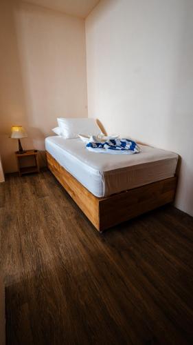 a bedroom with a large bed with a white mattress at Beach Lily Dhigurah in Dhigurah