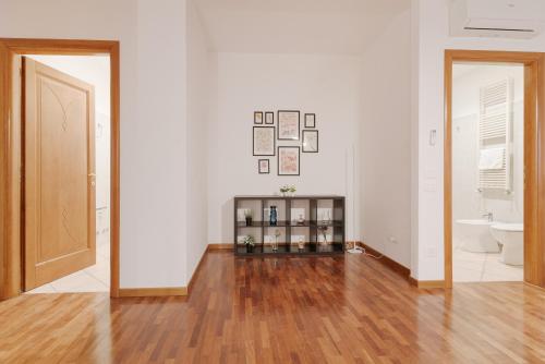 a room with white walls and a wooden floor at Spacious Apartment 600 mt to Metro M3 Comasina in Milan
