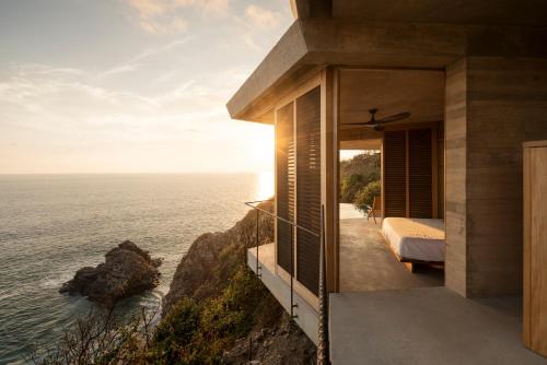 a bedroom with a view of the ocean at La Valise Mazunte, Member of Small Luxury Hotels in Zapotal