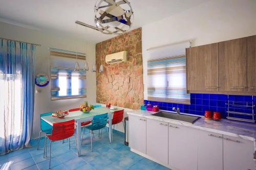 a kitchen with a sink and a table with chairs at Villa Amor in Pefki Rhodes