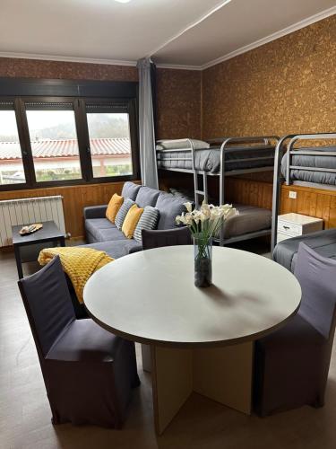 sala de estar con mesa, sillas y literas en El Camino, en Laza