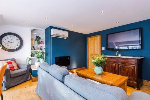 a living room with two couches and a flat screen tv at The Knutsford Townhouse by Staycay in Knutsford