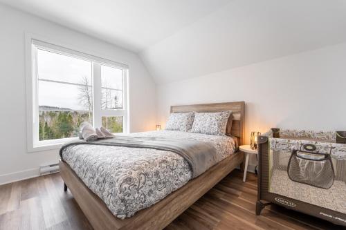 a bedroom with a large bed and a window at Le Raffine hot tub River Front in Saint Come