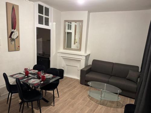 un salon avec un canapé et une table dans l'établissement Lovely place in Caen's historic center, à Caen