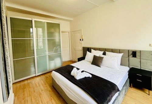 une chambre avec un grand lit avec des draps blancs dans l'établissement Lovely place in Caen's historic center, à Caen