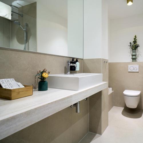 a bathroom with a white sink and a toilet at Hotel Engbert in Oelde