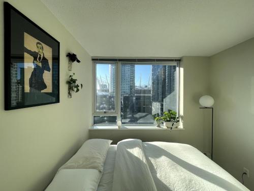 a bedroom with a bed and a window at Downtown Apartment in Vancouver
