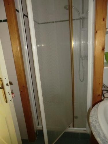 une douche en verre dans une salle de bain avec un lavabo dans l'établissement DOUARNENEZ Tréboul près des plages, à Douarnenez