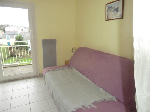 - un petit lit violet dans une chambre avec fenêtre dans l'établissement DOUARNENEZ Tréboul près des plages, à Douarnenez