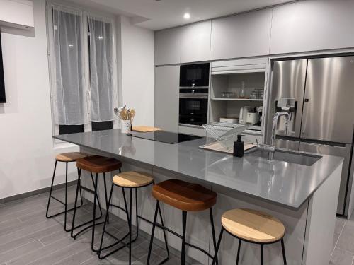 La cuisine est équipée d'un comptoir avec tabourets et d'un réfrigérateur. dans l'établissement Maison Fair play, jardin, parking, billard, à Maisons-Alfort