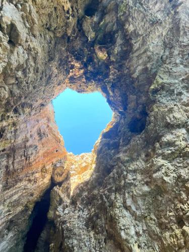 a view from inside a rock formation at Villa Eos con Piscina Privata nel cuore del Parco Naturale di Andrano in Andrano