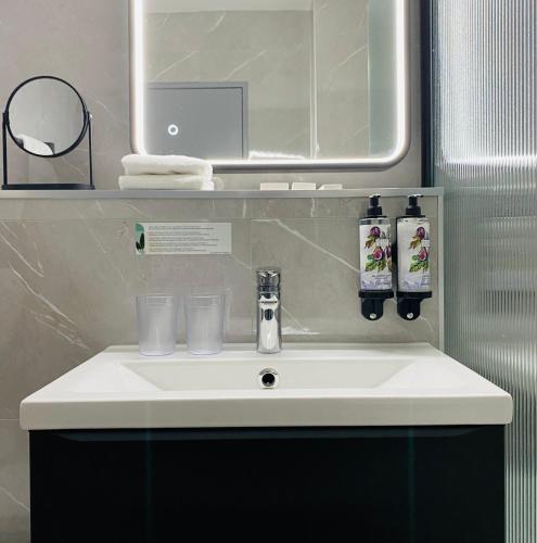 une salle de bain avec un lavabo blanc et un miroir dans l'établissement Studio Galerie 466 L'art de vivre à Metz, à Metz