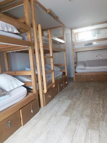 a room with four bunk beds and a wooden floor at Cachinnans Hostel & apartaments in Vila do Conde