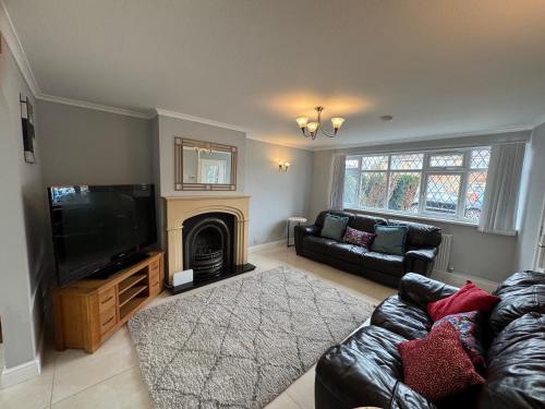 a living room with a couch and a television at Cosy Guest House, Langley, Slough in Langley Station