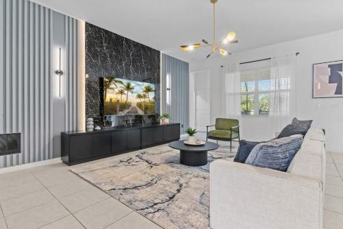 a living room with a couch and a table at SUPER GIANT - 12BD 12BAs - SLEEP 38 & NEAR DiSNEY in Kissimmee