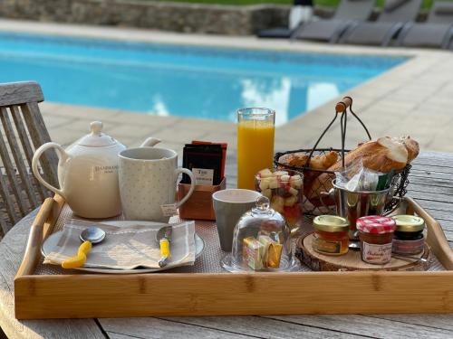 a tray of breakfast food on a table next to a pool at Marquise Barbot in Evry-Courcouronnes