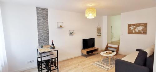 a living room with a couch and a tv at Cœur d'émeraude in Moissac
